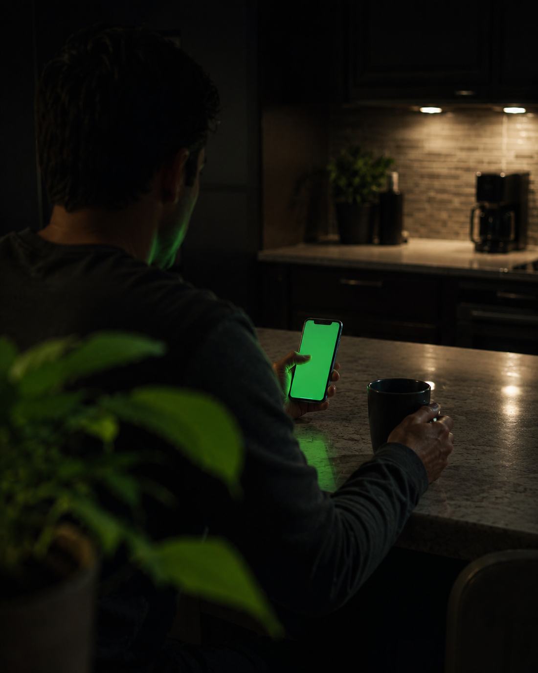 An investor checking their portfolio on a phone in a dark kitchen